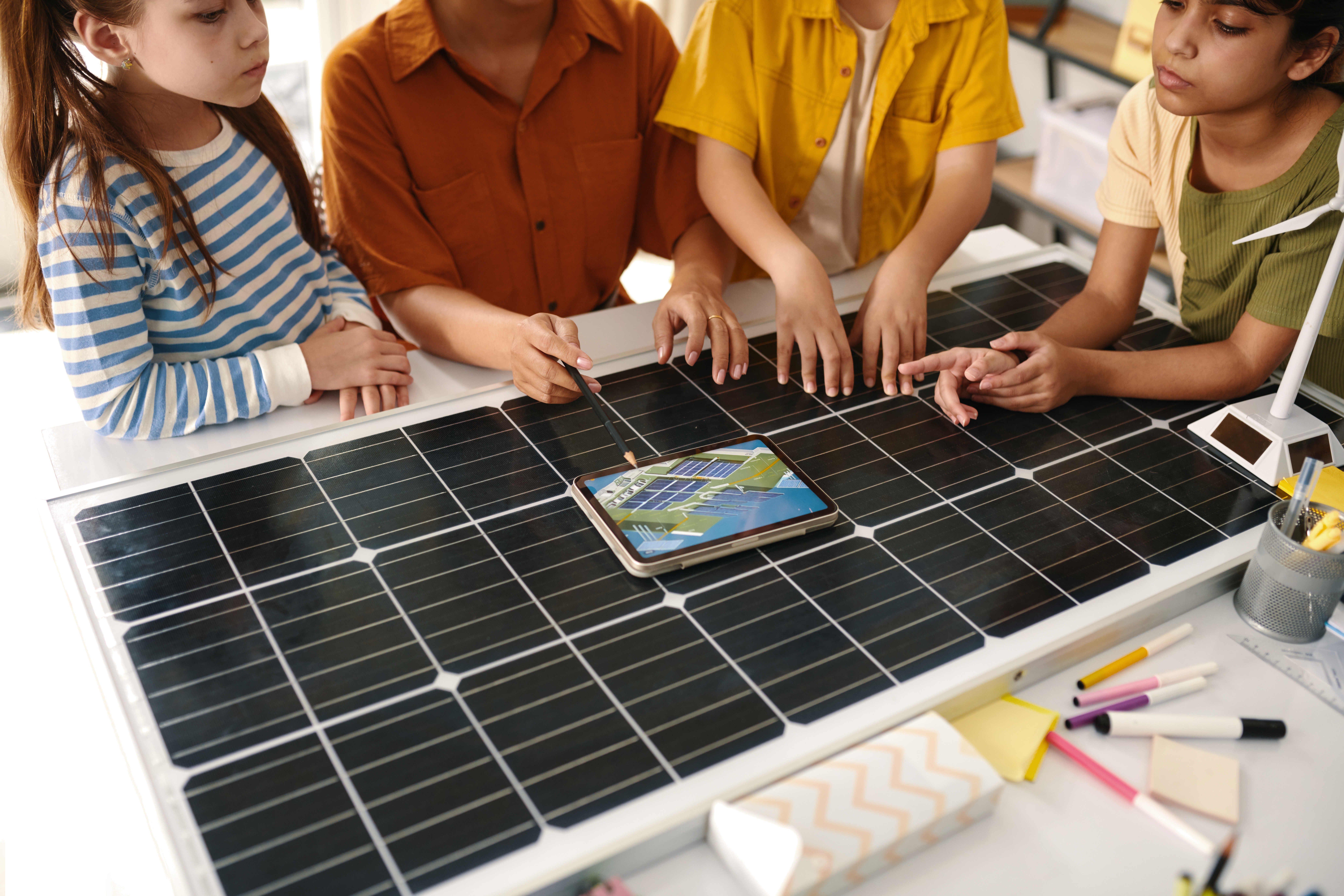 A group of students huddled around a solar panel.
