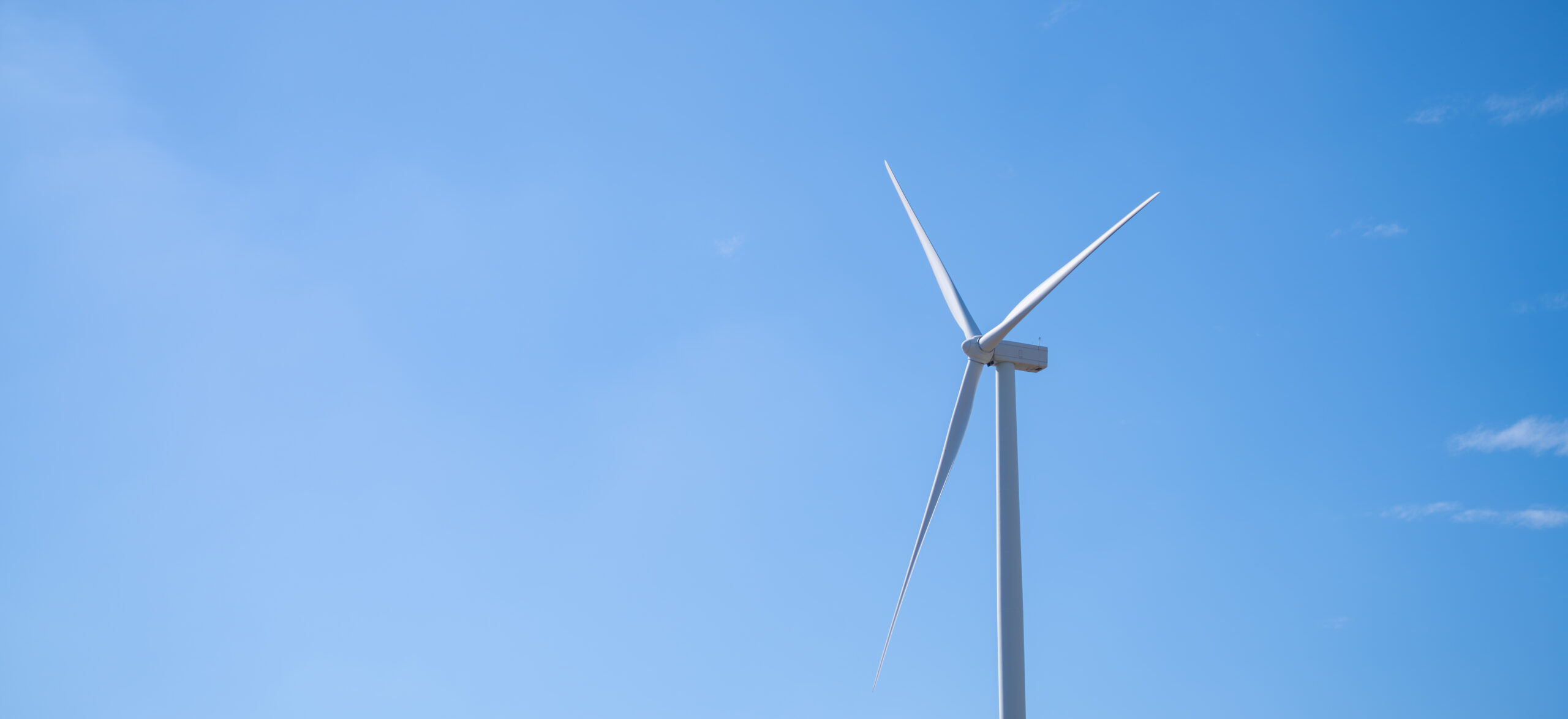 Wind turbine in front of blue sky.